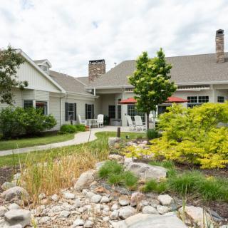 A beautiful house surrounded by a well-maintained garden and lush greenery.