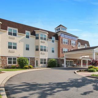 A hotel building with a landscaped entrance and a driveway.