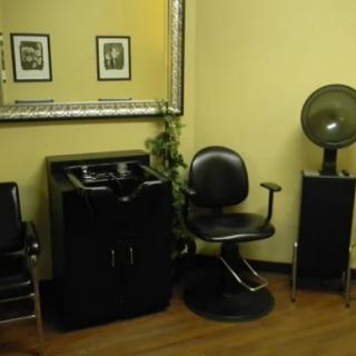 A cozy hair salon interior with chairs, a mirror, and a hair dryer.