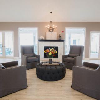 A modern and cozy living room with a central seating area around a fireplace.