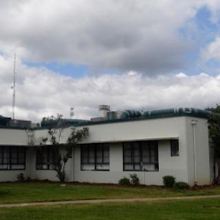 A modern commercial building set against a cloudy sky.