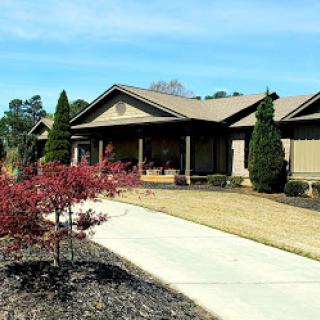 A beautiful single-story house with landscaped gardens and a welcoming front porch.