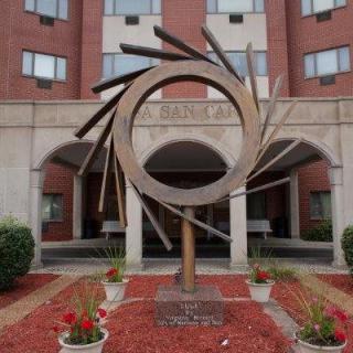 Modern sculpture in front of a multi-story building.