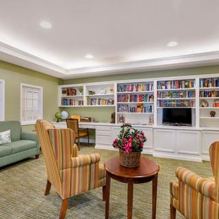 A cozy living room with bookshelves, comfortable seating, and a television.