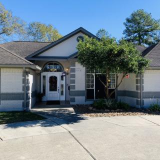 A view of a residential house with a driveway and front yard.