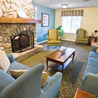 A cozy living room with a stone fireplace and comfortable seating.