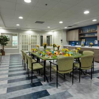 A modern dining room setup with a long table and chairs, ready for a meeting or gathering.