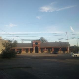 A view of a brick building with a clear sky and surrounding landscape.