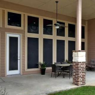 A patio area featuring outdoor furniture, large windows, and a ceiling fan.