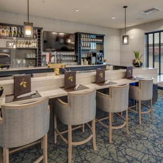A modern bar interior with a sleek counter and comfortable seating.