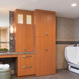 A modern bathroom interior featuring wooden cabinets and a vanity with a mirror.