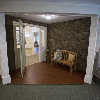 Cozy entrance with a stone wall and wooden bench.