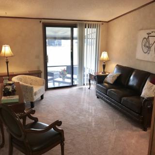 A cozy living room with comfortable seating, warm lighting, and decorative artwork.