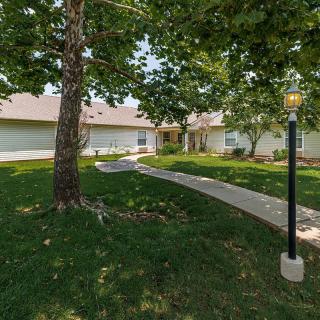 A residential house with a lush green yard and a pathway leading to the entrance.