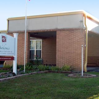 A brick office building with a prominent sign and well-maintained landscaping.