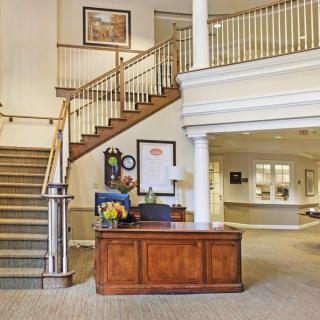 A welcoming reception area with a wooden desk and staircase.