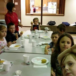 A group of children enjoying a meal together at a dining table.