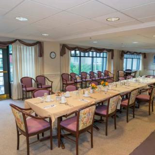 A formal conference room set up with a long meeting table and multiple chairs.