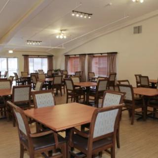 An empty dining room with neatly arranged tables and chairs.