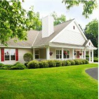 A charming suburban house with a well-maintained lawn and front porch.