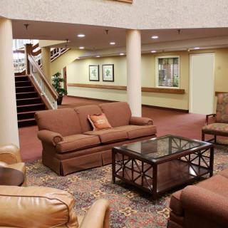 A cozy lobby area with sofas, a coffee table, and carpeted flooring.