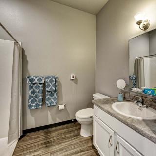 A modern bathroom with a shower, sink, toilet, and decorative towels.