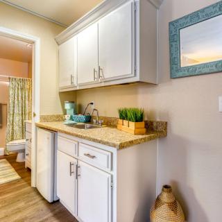 A beautifully designed kitchen with white cabinets, wooden countertops, and decorative elements.