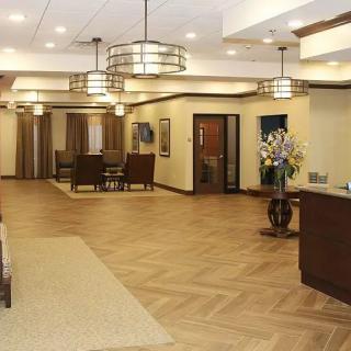 A spacious and modern lobby area with elegant lighting and wood flooring.