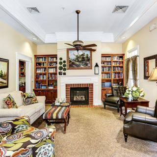 A cozy living room with a fireplace surrounded by bookshelves, featuring comfortable seating and tasteful decor.