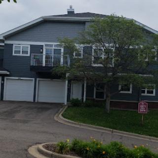 A modern residential building with garages and landscaped greenery.