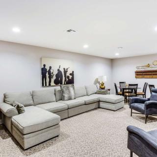 A modern living room featuring a large sectional sofa, accent chairs, and a dining area in the corner.