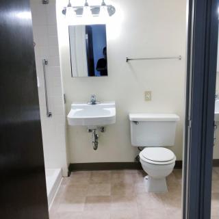 A minimalist bathroom with a sink, mirror, and toilet.