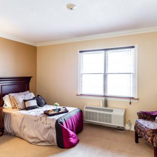 A cozy bedroom with a bed, window, and tasteful decor.