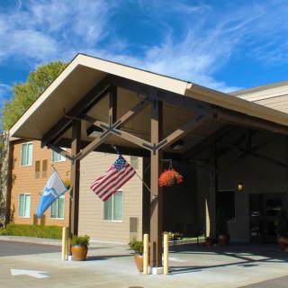 A building entrance with flags displayed under a clear blue sky.