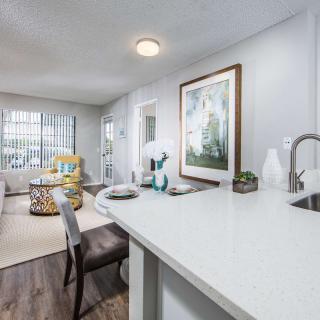 A modern open-plan apartment interior featuring a kitchen and living area with stylish decor.