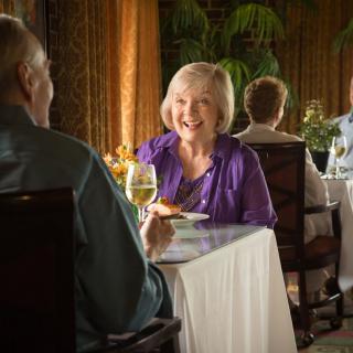 An elderly couple enjoying a meal together in a cozy restaurant.