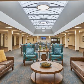 A spacious and modern lounge area with comfortable seating and a skylight ceiling.