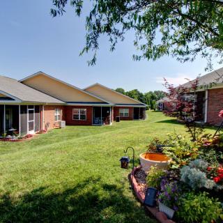 A peaceful suburban backyard with manicured lawns and vibrant gardens.