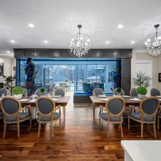 A sophisticated dining room featuring modern decor, elegant chandeliers, and a stunning view through large windows.