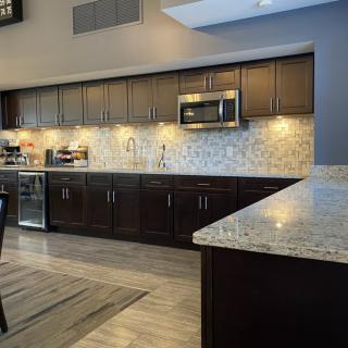 A sleek, modern kitchen featuring dark wooden cabinets and granite countertops.