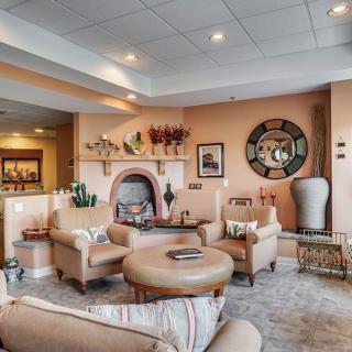 A stylish living room with a cozy seating area featuring a fireplace and modern decorative elements.