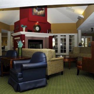 A cozy living room with comfortable seating around a central fireplace.