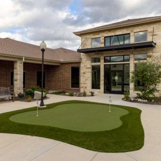 A modern building courtyard featuring a putting green.