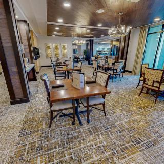 A spacious, elegantly designed dining room with modern furnishings and ample lighting.