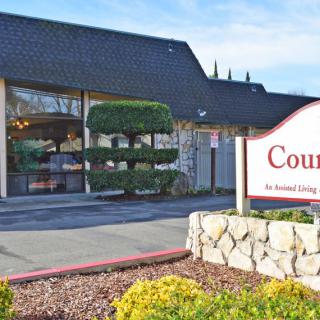 Entrance to an assisted living facility with landscaped surroundings.