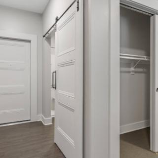 A view of a stylish interior featuring sliding and standard doors leading to a closet space.