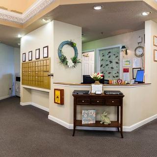 A well-decorated office reception area featuring a desk, mailboxes, and a wreath on the wall.