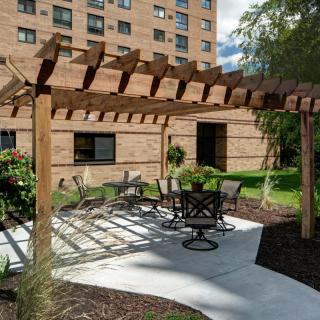 Outdoor seating area with a pergola near a building