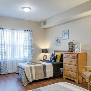 A cozy bedroom with two beds, a dresser, and decorative elements.