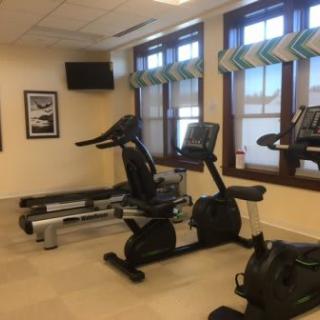 An indoor gym area with exercise equipment including treadmills and stationary bikes.